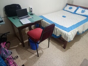 A small room with a bed, a desk with a laptop, a chair, and a bicycle. - Ibis hotel Nyeri (Nyeri)