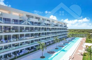 A multi-story hotel with balconies, a swimming pool, and a view of the landscape. - Aqua Poolside Serenity | Pool  & Golf  2B Cana Bay (Bavaro)