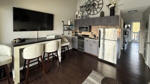A modern kitchen with a central island, dark wood flooring, and a ceiling fan. - Welcome to Your Lakefront Retreat (Osage Beach)