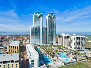 A high-rise hotel with a pool area, multiple balconies, and a view of the ocean. - Wake to Gulf Views! 7th Floor Luxury at Sapphire! (South Padre Island)