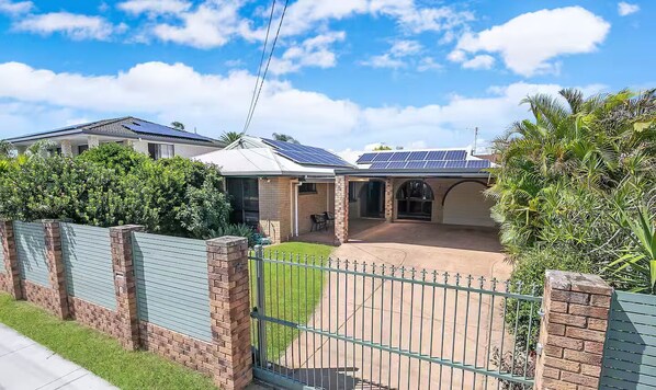A residential property with a gated driveway, solar panels on the roof, and a covered patio area. - Entire home in Kippa-Ring, Australia (Kippa-Ring)