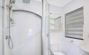 A modern bathroom with a glass-enclosed shower, a toilet, and a sink. - Entire home in Kippa-Ring, Australia (Kippa-Ring)