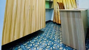 A room with a geometric patterned floor, wooden wardrobes, and a ceiling light. - Northwood Gardens & Adventure Park (Mukurweini)