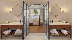 A mirrored bathroom with two sinks, a bed, and a view of a balcony. - The Postcard on The Mandovi River (Alto de Porvorim)