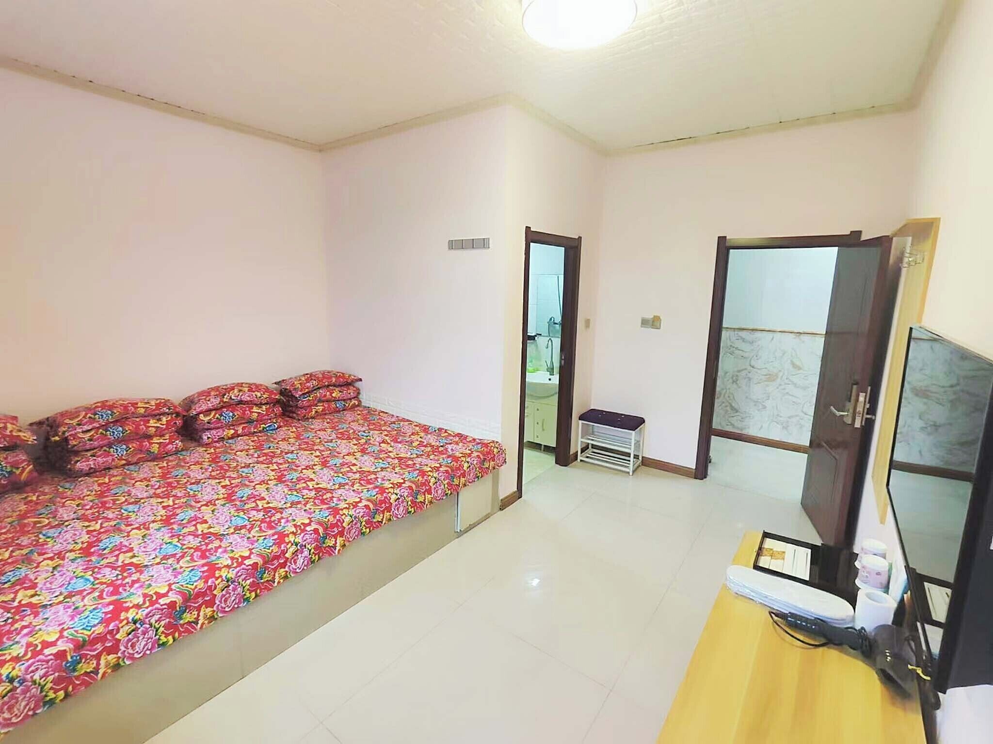 Un dormitorio con cama, escritorio, silla y televisor.