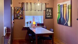 Een eethoek met een tafel, stoelen, een lamp en een raam met uitzicht.