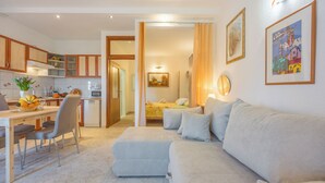 A modern living room with a sofa, a dining area with chairs and a table, and a kitchen with cabinets and appliances. - Amalija Sea View Studio  Apartment 4, Mali Lošinj, Croatia (Mali Lošinj)