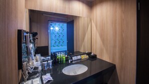 A modern bathroom with a large mirror, a black sink, and various toiletries. - hoteru saphir (Toyama)
