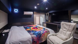 A hotel room with a bed, a chair, a desk with a computer, and a minibar. - hoteru saphir (Toyama)