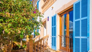 A traditional building with stone walls, blue shutters, and a wooden staircase leading to a balcony. - PUNTA LLARGA - Cozy house with sea views, private pool and free Wi-Fi (Artà)