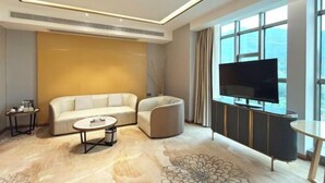 A modern living room with a sofa, coffee table, and TV. - Guiping Ruquan Jingliugang Hotel (Xishan Branch) (Guiping)