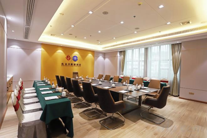 A conference room with a long table, chairs, and a flag.