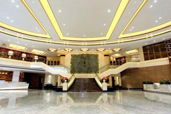 A spacious lobby with a grand staircase, multiple levels, and a large decorative wall. - Guiping Ruquan Jingliugang Hotel (Xishan Branch) (Guiping)