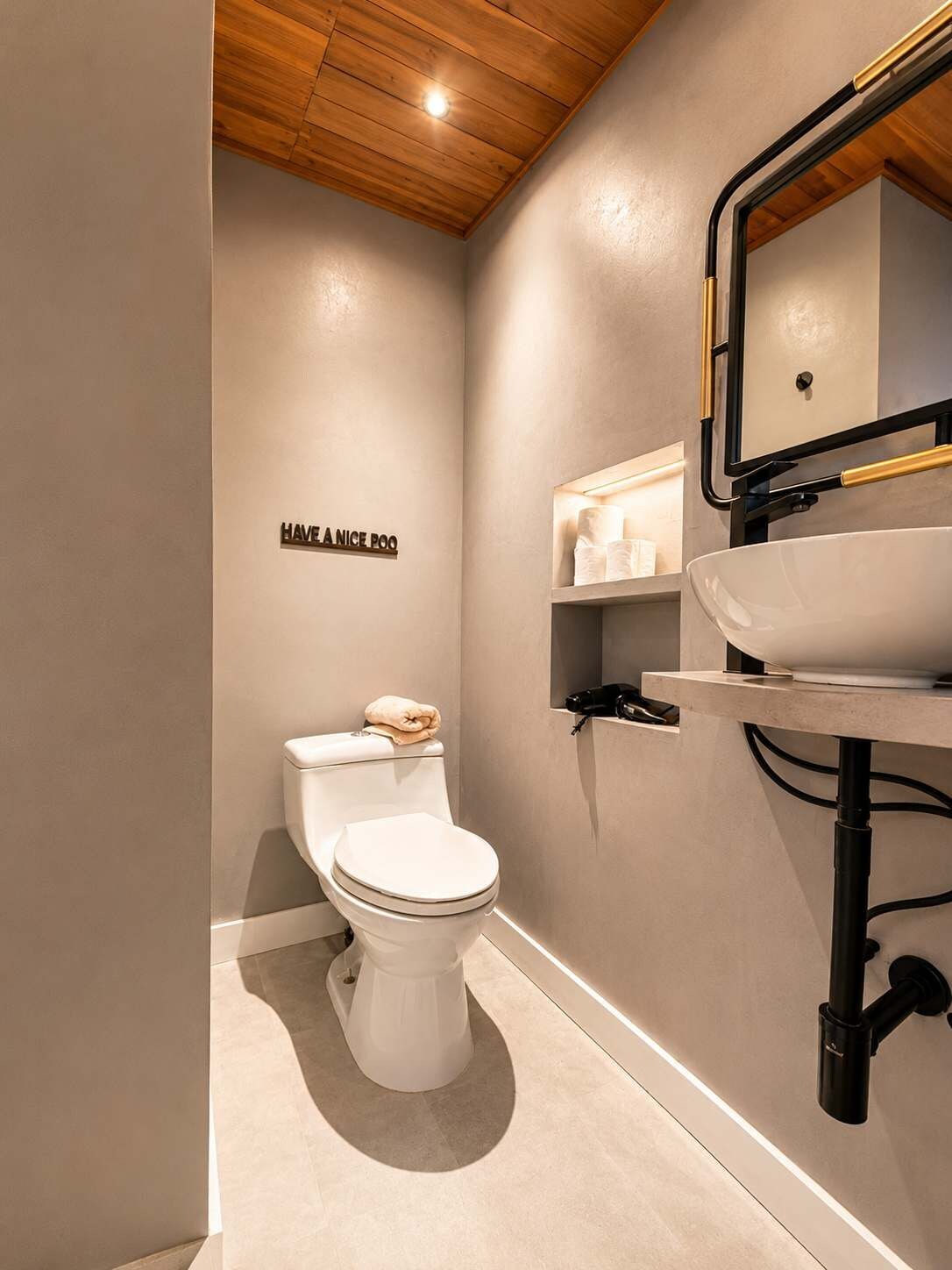 A modern bathroom with a toilet, a sink, and a mirror.