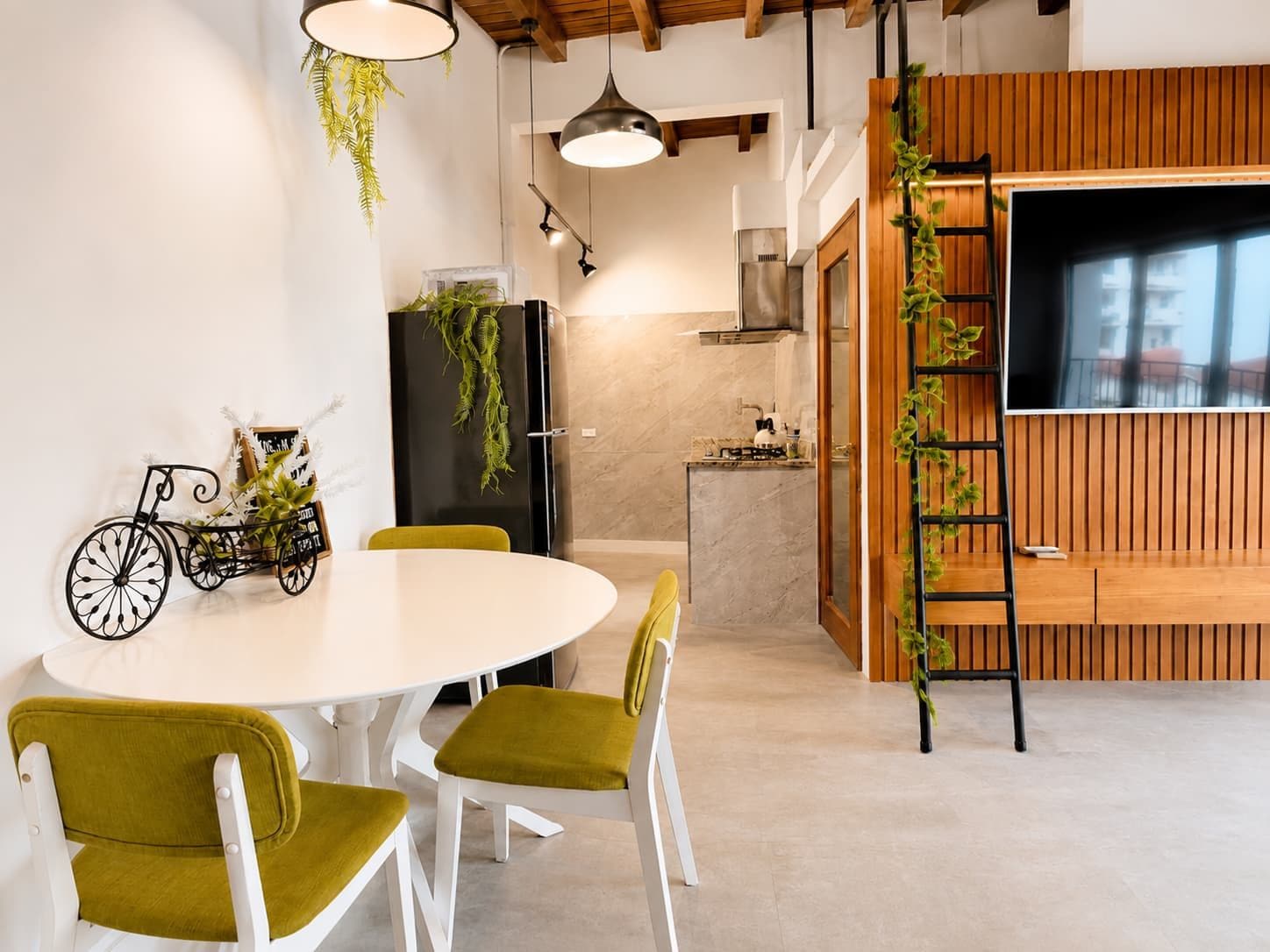A modern kitchen with a built-in stove, a refrigerator, and a wooden wall panel.