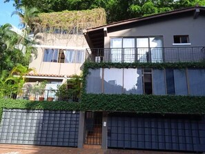 Ein mehrgeschossiges Wohngebäude mit Balkon, Garage und befahrbarer Einfahrt.