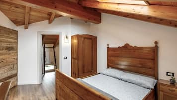 Een slaapkamer met een houten bed, een kast en een houten plafond.