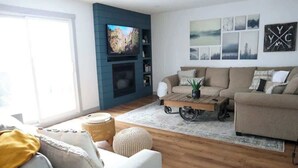 Ein Wohnzimmer mit Fernseher, Sofa und Couchtisch.