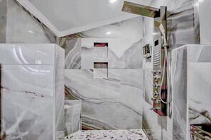 Un bagno con pareti in marmo e cabina doccia.
