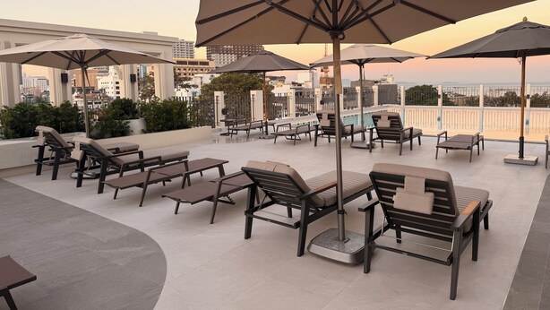 A rooftop terrace with outdoor seating and umbrellas, overlooking a cityscape. - Aston Hotel Pattaya (Pattaya)