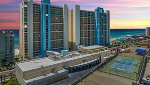Un hôtel composé de plusieurs immeubles de grande hauteur, doté d’un court de tennis et offrant une vue sur l’océan.