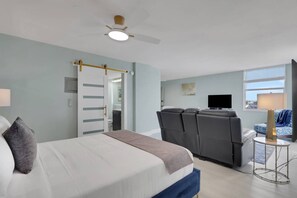 Ein Hotelzimmer mit einem Bett, einem Massagesessel, einem Fernseher und einem Fenster mit Jalousien.