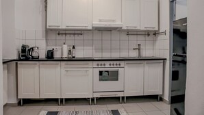 Eine moderne Küche mit weißen Schränken, einem Herd und einer Kaffeemaschine.
