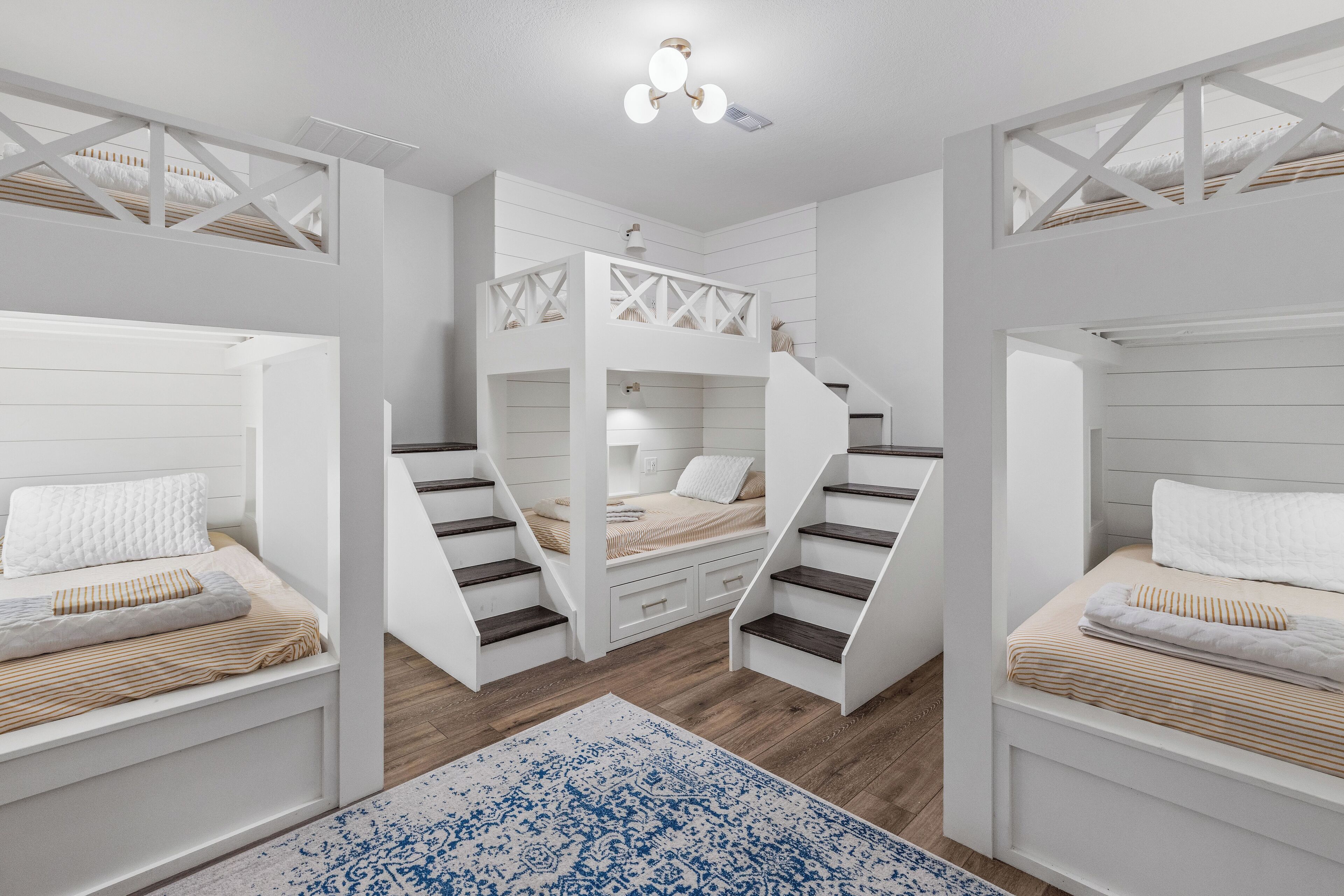 Una habitación con literas, una escalera y una alfombra estampada.