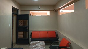 A waiting area with a bench, a table, and a door. - Silver Brooke Hotel Othaya (Othaya)