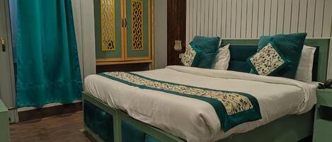 Un dormitorio con cama, cortinas, un armario y una mesita de noche.