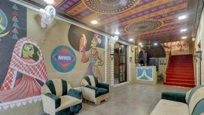 Un hall d’entrée agrémenté de peintures murales colorées, un escalier et des espaces où l’on peut s’asseoir.