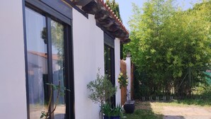 A building with a tiled roof, large windows, and potted plants along the pathway. - Jetez l'Ancre - Gîte pour ralentir in La Tremblade (La Tremblade)