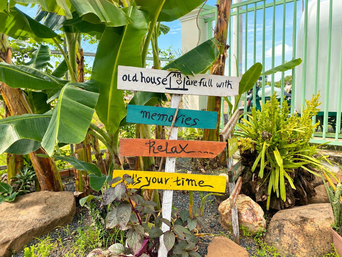 Un cartel con varios indicadores en un jardín.