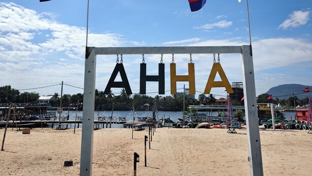 Une plage avec deux drapeaux et un panneau indiquant « AHHA ».