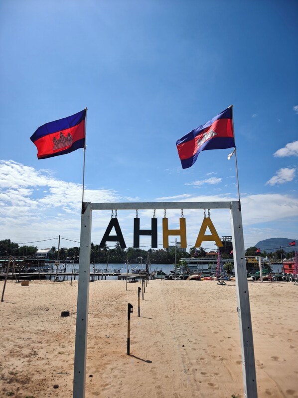 Une plage avec deux drapeaux et un panneau indiquant « AHHA ».