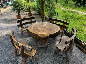 A round wooden table with benches, surrounded by gravel. - AHHA River Breeze Kampot  (Kampot)