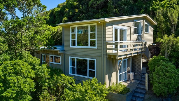 A two-story house with a balcony, surrounded by lush greenery. - Skyline Sanctuary: Green View, Bird Songs, Parking, Espresso & Netflix (Wellington)