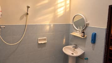 Ein Badezimmer mit Dusche, Waschbecken und Spiegel.