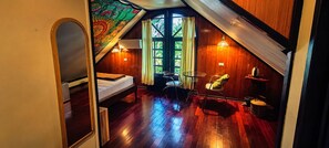 A small, cozy room with a bed, a table, and a chair. There is a window with curtains and a view of greenery outside. - Marissa Hotel (Ko Pha-ngan)