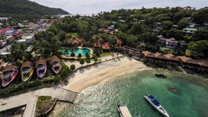 An aerial view of a coastal resort with a swimming pool, beach, and boats. - Marissa Hotel (Ko Pha-ngan)