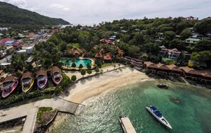 An aerial view of a coastal resort with a swimming pool, beach, and boats. - Marissa Hotel (Ko Pha-ngan)