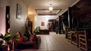 A spacious hallway with a wooden bench, potted plants, and a hanging light fixture. - Marissa Hotel (Ko Pha-ngan)
