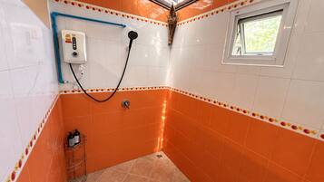 A bathroom with orange tiles, a shower, a window, and a towel rack.