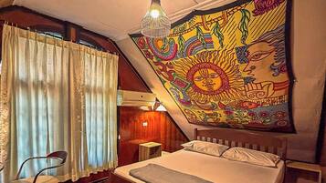 Quarto com cama, cadeira, tapeçaria e luminária pendente.