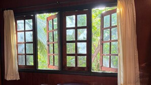 A room with a wooden floor, a round table with two chairs, and a window with curtains. - Marissa Hotel (Ko Pha-ngan)