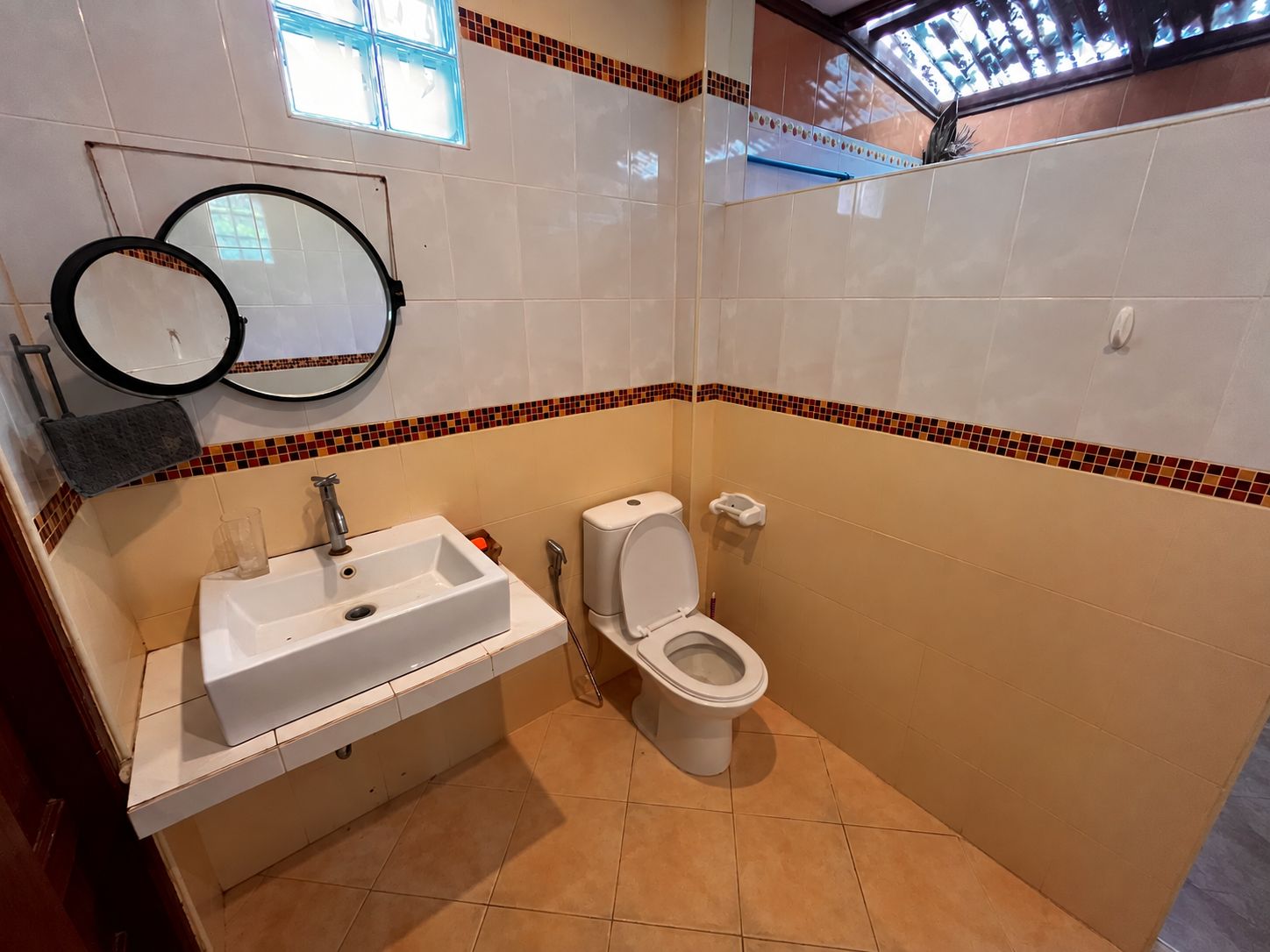 Un baño con lavabo, inodoro y espejo.