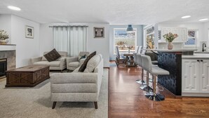 Un salon moderne comprenant un canapé, une table basse et un coin repas avec un bar.