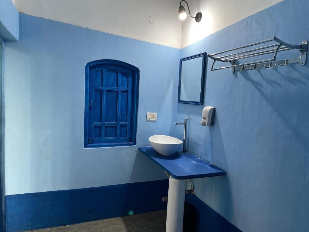 Een badkamer met een blauw-wit kleurenschema, een raam, een wastafel en een handdoekhouder.