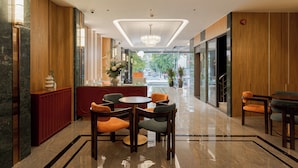 A modern lobby with a reception desk, seating area, and a chandelier. - NiK Hotel Thi Sach (Ho Chi Minh City)