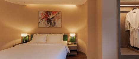 Habitación de hotel con una cama grande, dos mesitas de noche con lámparas, un cuadro en la pared y un vestidor con una bata colgada.